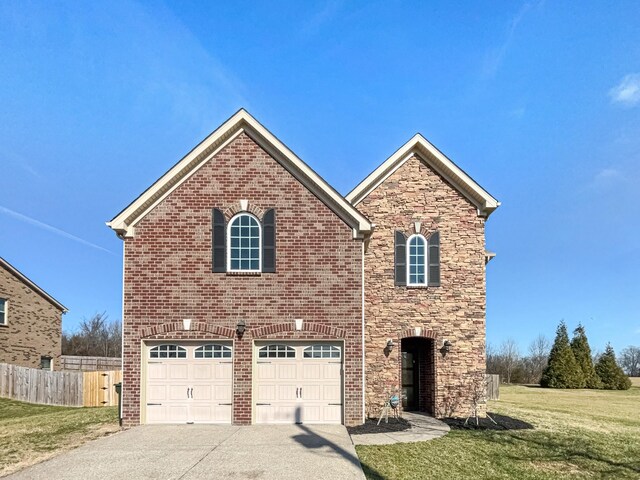 traditional home featuring brick siding, concrete driveway, a front yard, and fence