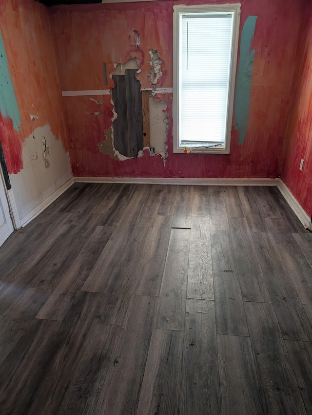 unfurnished room with dark wood-style floors and baseboards