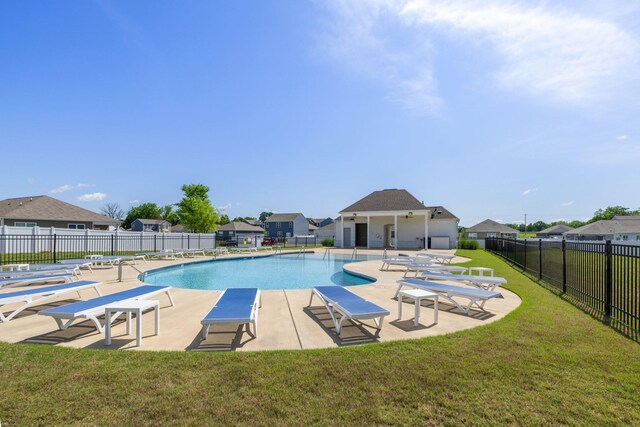 pool featuring a patio area, a residential view, a yard, and fence