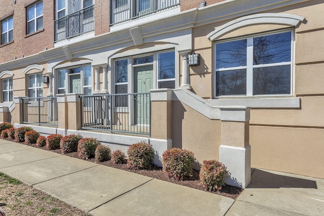 property entrance featuring a residential view and stucco siding