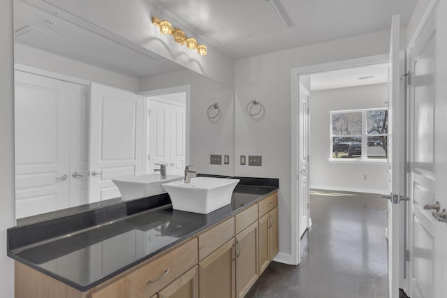 full bath featuring double vanity, baseboards, concrete floors, and a sink