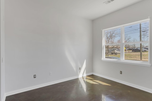 empty room featuring visible vents, concrete floors, and baseboards