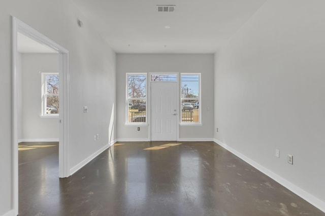 spare room featuring a wealth of natural light, visible vents, and baseboards