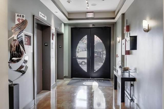 entryway with french doors, elevator, and concrete flooring