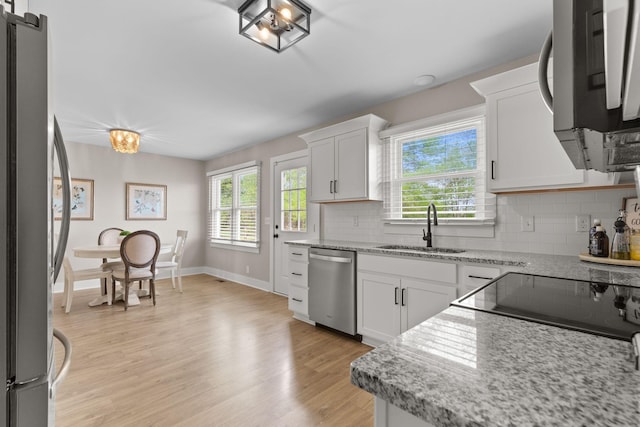 2436 J D Todd Rd, Murfreesboro, TN 37129 - kitchen featuring stainless steel appliances, a sink, light wood-type flooring, backsplash, and white cabinetry