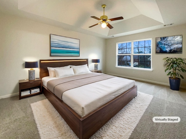 bedroom featuring a raised ceiling, carpet, visible vents, and baseboards