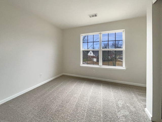 empty room with carpet flooring, baseboards, and visible vents