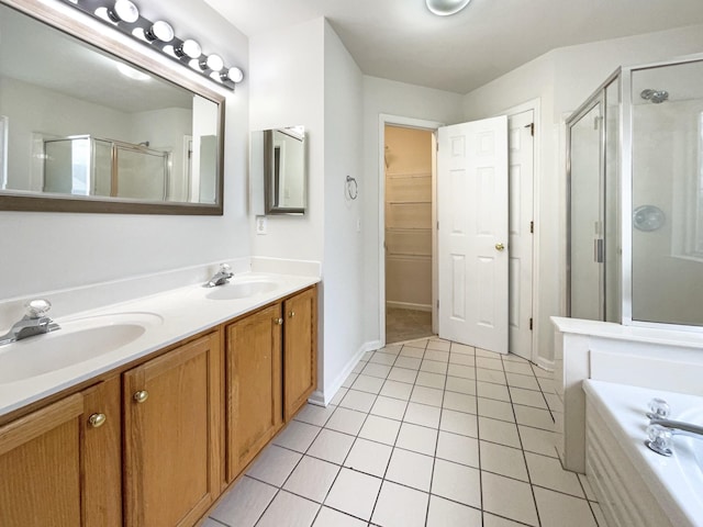 bathroom with tile patterned flooring, a shower stall, a garden tub, and a sink