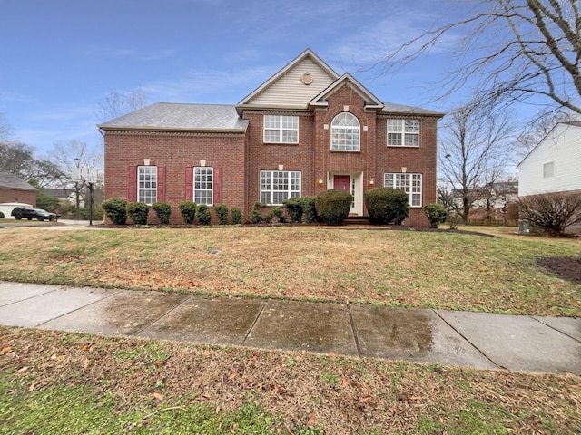 view of front of home featuring brick siding and a front lawn