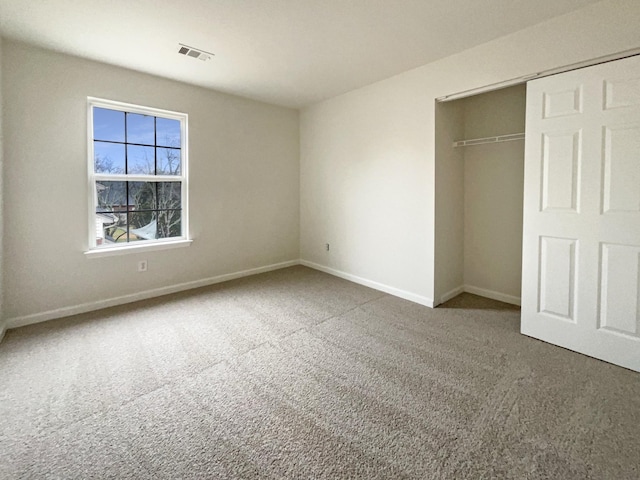 unfurnished bedroom with a closet, visible vents, baseboards, and carpet