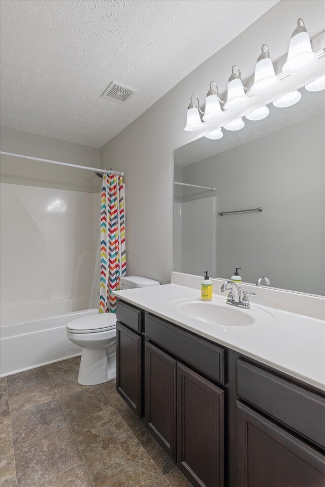 full bathroom featuring visible vents, toilet, vanity, shower / tub combo, and a textured ceiling