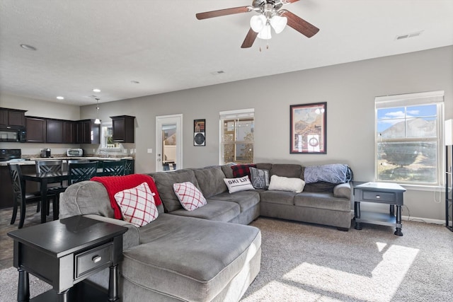 living room with visible vents, baseboards, ceiling fan, light colored carpet, and recessed lighting