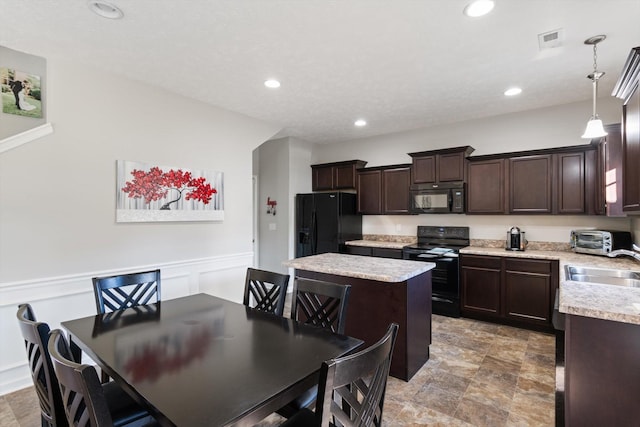 kitchen featuring visible vents, black appliances, a sink, dark brown cabinetry, and light countertops