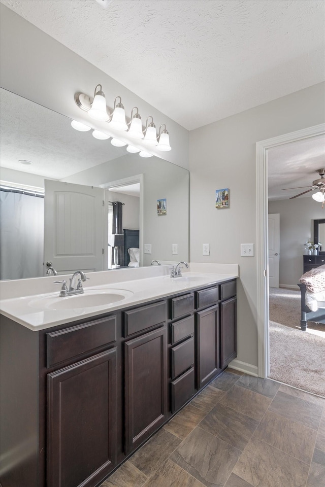 ensuite bathroom featuring a sink, connected bathroom, and double vanity