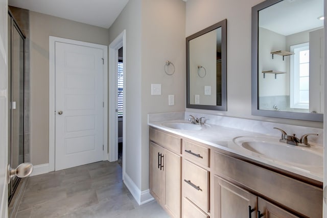 full bath with a shower stall, double vanity, and a sink