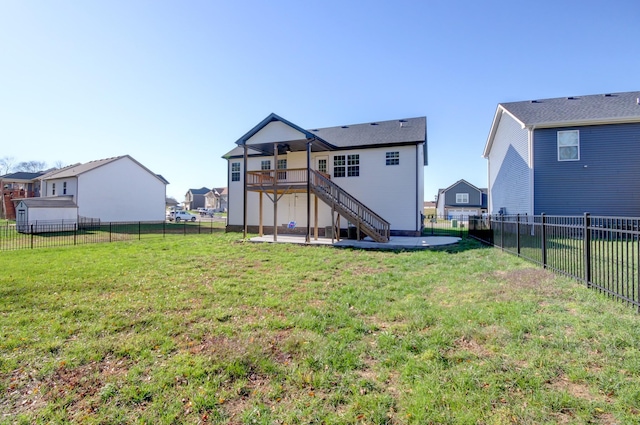 rear view of house featuring stairway, a wooden deck, a yard, a fenced backyard, and a patio