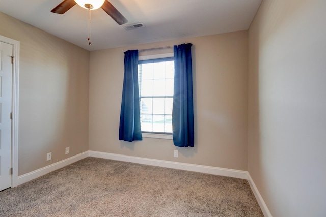 empty room featuring visible vents, carpet floors, baseboards, and ceiling fan