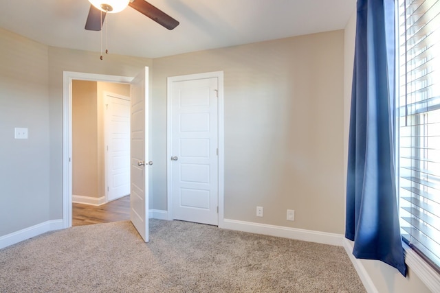 unfurnished bedroom with a ceiling fan, baseboards, and carpet floors