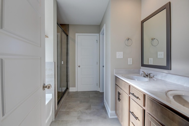 full bath featuring double vanity, a stall shower, and a sink