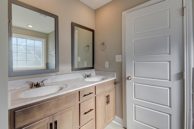 bathroom featuring double vanity, visible vents, and a sink