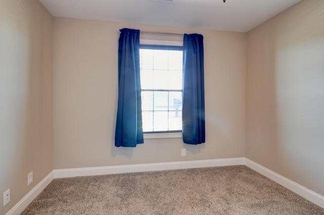 spare room featuring visible vents, baseboards, and carpet