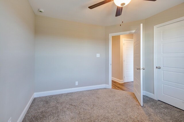 unfurnished bedroom with light carpet, ceiling fan, and baseboards