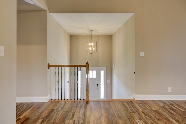 entrance foyer featuring an inviting chandelier, baseboards, and wood finished floors