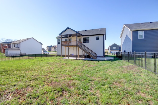 rear view of house featuring a wooden deck, stairway, a yard, and a fenced backyard