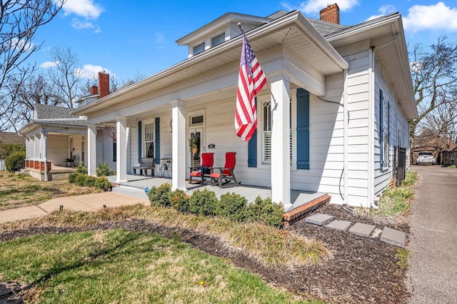 view of front of home with covered porch and a chimney