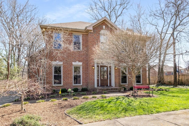 colonial house with brick siding and a front yard