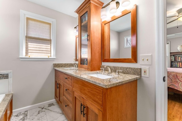 full bathroom featuring connected bathroom, marble finish floor, baseboards, and a sink