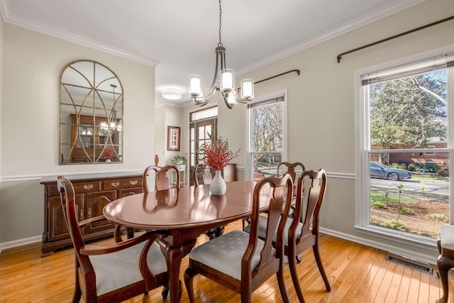 dining room with visible vents, light wood-style flooring, crown molding, and a healthy amount of sunlight