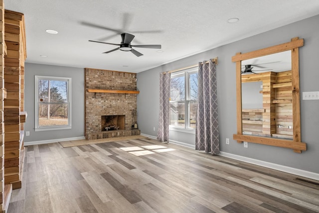 928 Red Bird Ln, Cumberland Furnace, TN 37051 - unfurnished living room featuring a ceiling fan, wood finished floors, visible vents, baseboards, and a fireplace