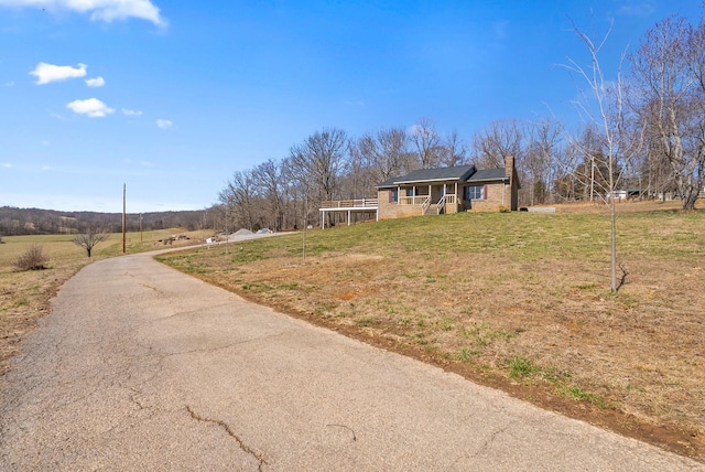 view of front of property with a rural view and a front lawn