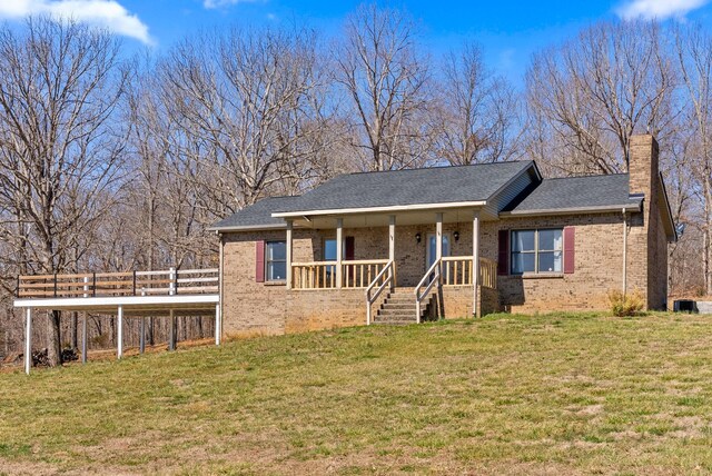 928 Red Bird Ln, Cumberland Furnace, TN 37051 - ranch-style home with brick siding, covered porch, a chimney, and a front lawn