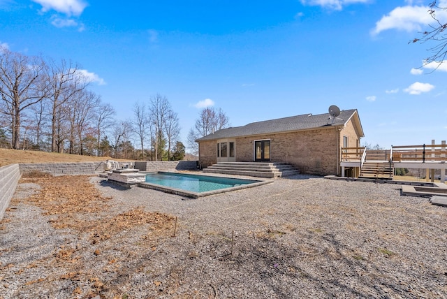 928 Red Bird Ln, Cumberland Furnace, TN 37051 - back of property featuring a deck, stairway, a fenced in pool, brick siding, and a patio area