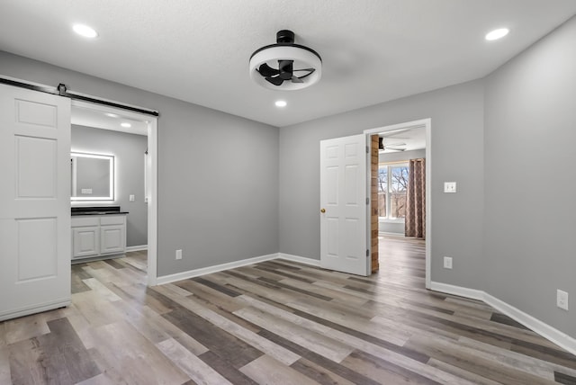928 Red Bird Ln, Cumberland Furnace, TN 37051 - interior space with recessed lighting, a barn door, baseboards, and light wood-style flooring