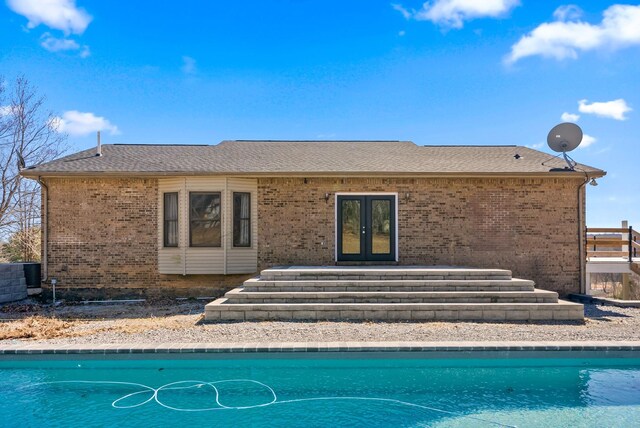 928 Red Bird Ln, Cumberland Furnace, TN 37051 - rear view of house with an outdoor pool, french doors, brick siding, and roof with shingles