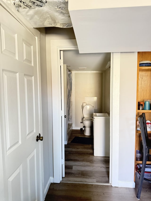 hallway featuring dark wood-style floors and baseboards