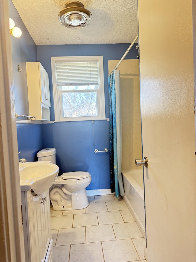 full bath featuring toilet, a textured ceiling, shower / tub combo, tile patterned flooring, and vanity