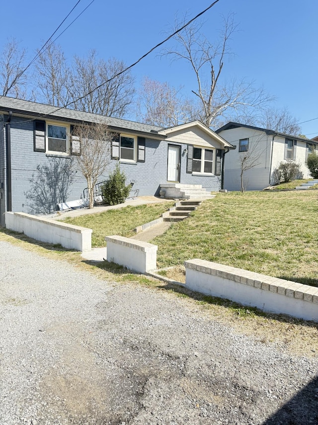 single story home featuring brick siding and a front lawn