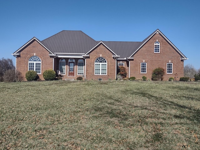 ranch-style home featuring a front lawn, brick siding, and metal roof