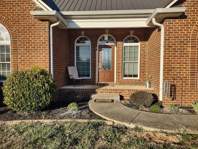 doorway to property with brick siding and covered porch