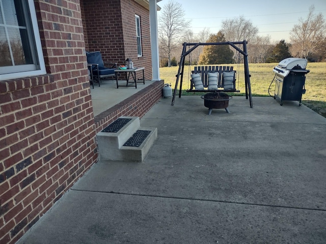 view of patio with grilling area and an outdoor living space with a fire pit