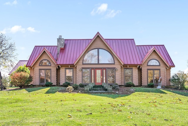 view of front facade with metal roof, a front lawn, a chimney, and a standing seam roof