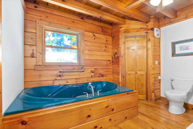 full bath featuring a garden tub, wood finished floors, wood walls, wooden ceiling, and beamed ceiling