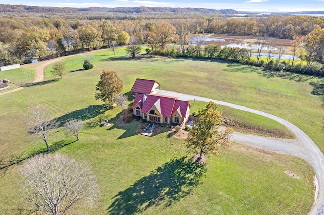 drone / aerial view with a forest view and a water view