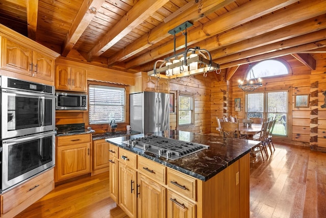 kitchen with an inviting chandelier, light wood finished floors, wood walls, and stainless steel appliances