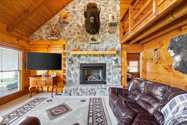 living room featuring beam ceiling, carpet floors, wooden walls, a stone fireplace, and wooden ceiling