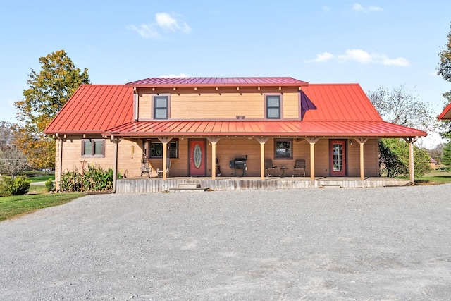 view of front facade with metal roof, covered porch, and a standing seam roof